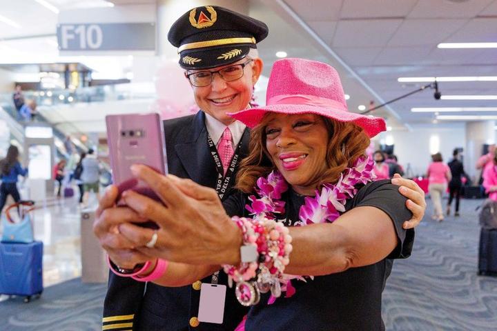 Delta employees pose for a photo before boarding Delta's Breast Cancer One charter